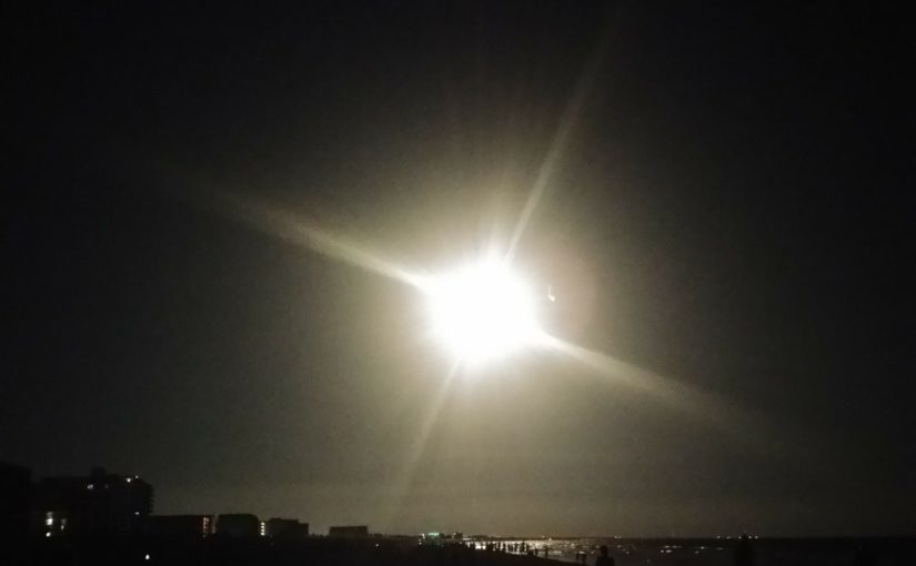 The bright light of a rocket engine taking off in the night
