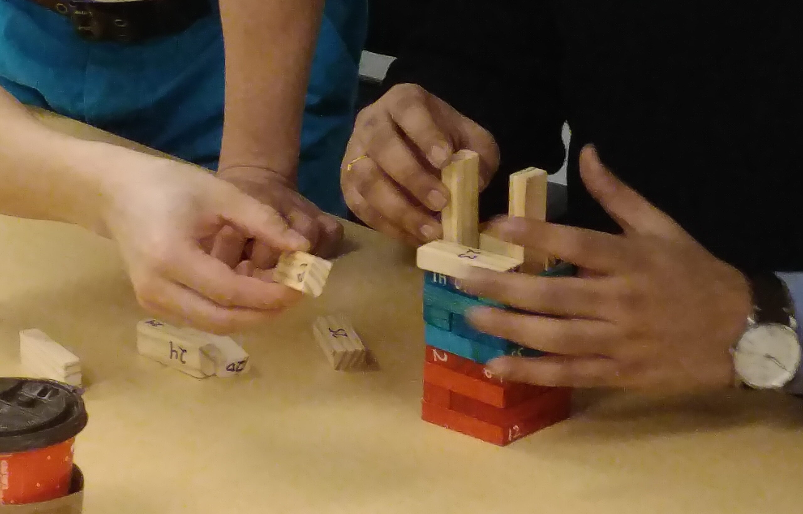 Two people building a tower from Jenga blocks